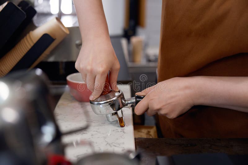 Cropped shot of woman barista making coffee, closeup view on hands stock image