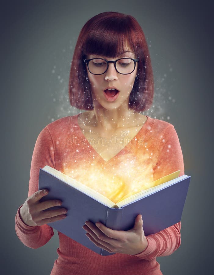 Captivated by an unexpected plot twist. A cropped shot of a young adult reading a book with glowing pages. royalty free stock photo