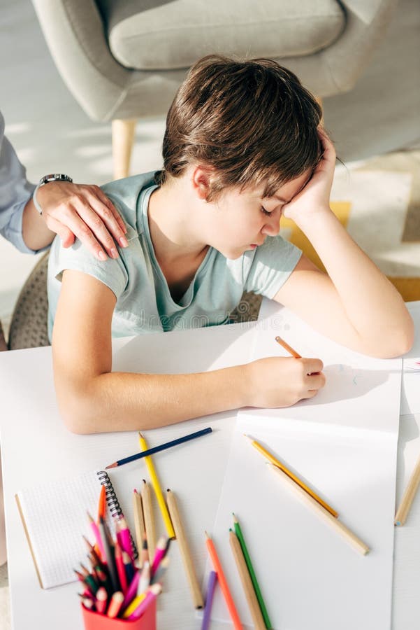 View of Child Psychologist Touching Sad Kid with Dyslexia Stock Photo