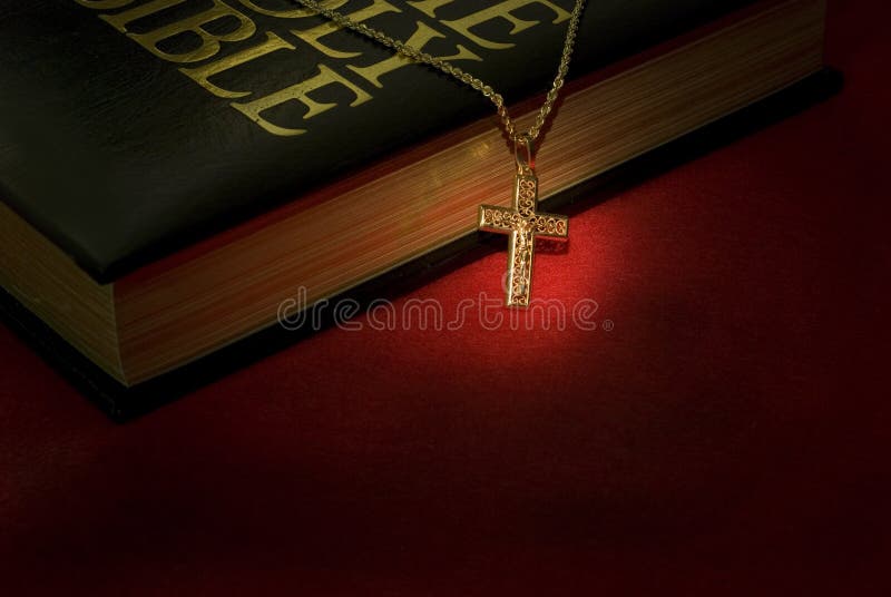 A gold cross necklace on a holy Bible. A gold cross necklace on a holy Bible