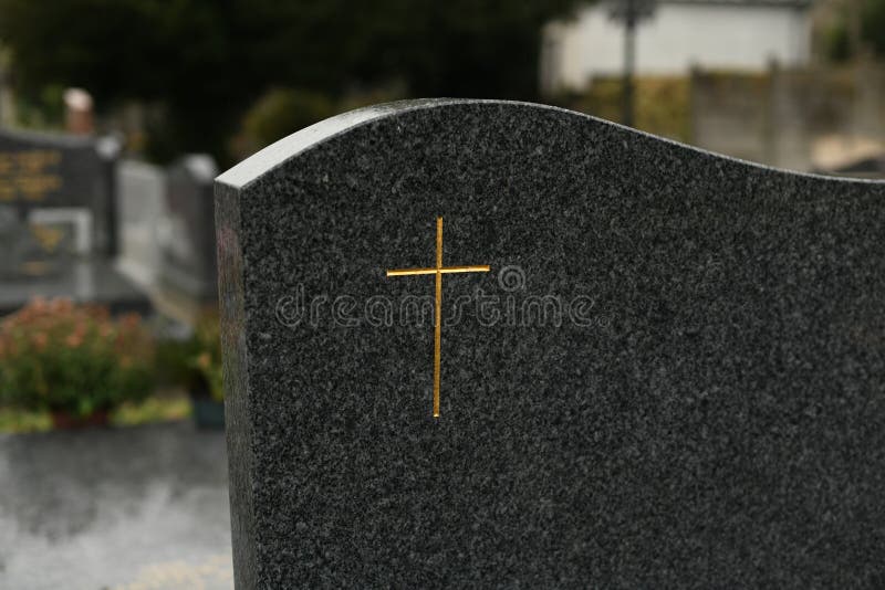 Cross on a Black Marble Slab on a Grave in a Cemetery Stock Image