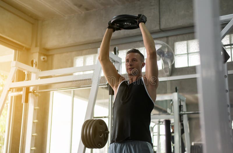 Cross fit body and muscular lifting weight bar in the gym,Sport man doing exercises training stock photos Cross fit body and muscular lifting weight bar in the gym,Sport man doing exercises training stock photos