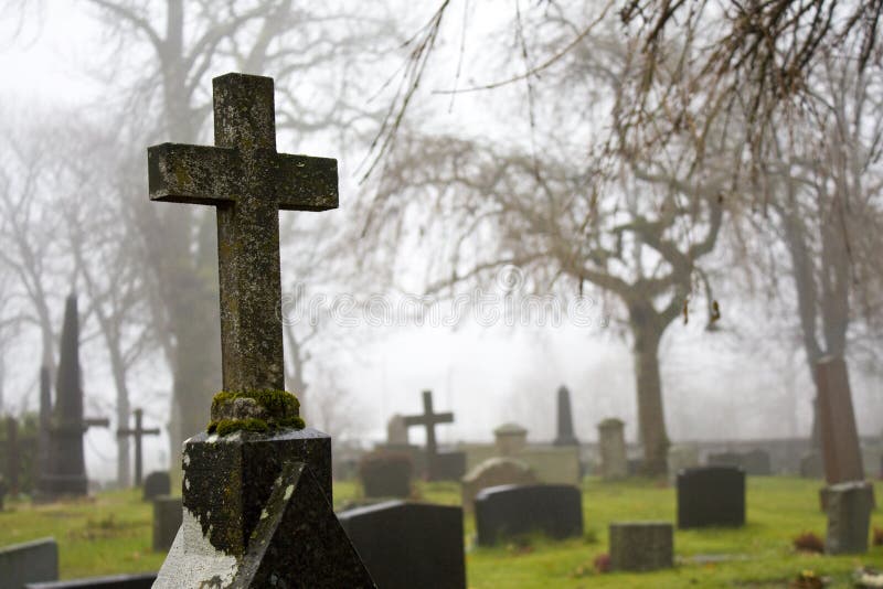 Cross at foggy autumn graveyard 2