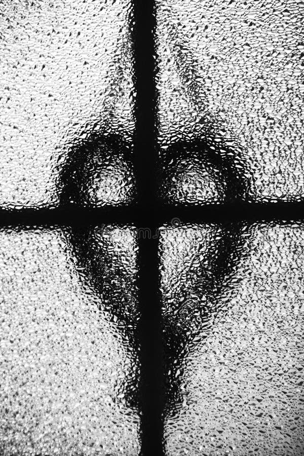 Cross and heart silhouette. Photographing through a glass window. royalty free stock photos