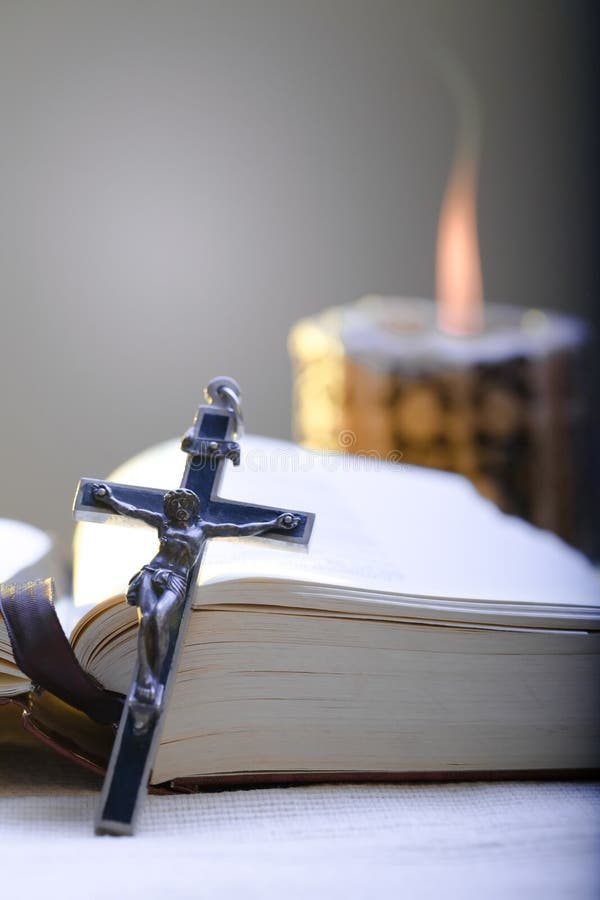 Alte Kreuz und die Bibel legen auf den Tisch direkt eine Beleuchtung Kerze.