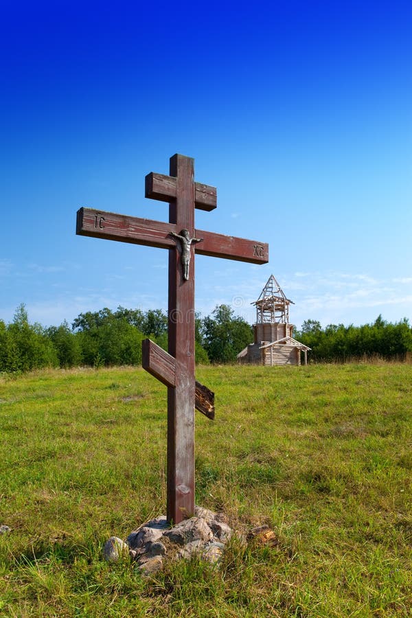 Cross in honor of the basis of church and under construction orthodox church on a hill