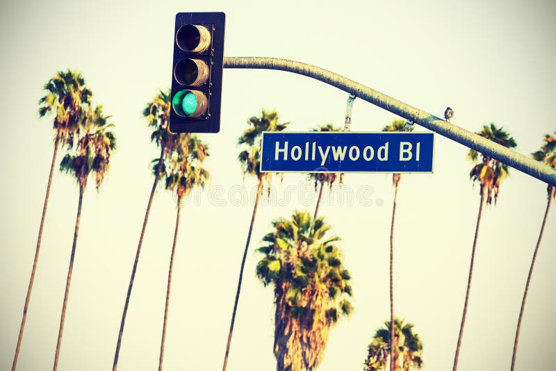 Cross processed Hollywood sign and traffic lights with palm trees.