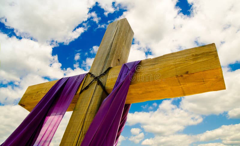 Cross with purple drape or sash for Easter. With blue sky and clouds in background stock photography