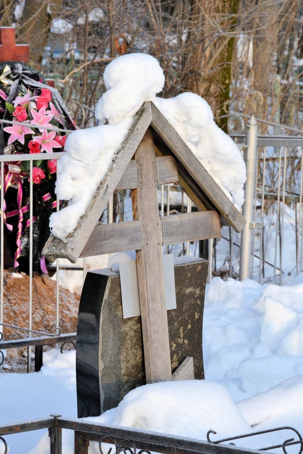 Crosses in a cemetery, monuments of the dead, a cemetery in winter, wreaths, artificial flowers. Russia stock photo Crosses in a cemetery, monuments of the dead, a cemetery in winter, wreaths, artificial flowers. Russia stock photo