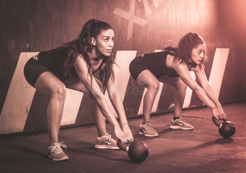 Crossfitters, das harte tägliche wod kettlebells ausbildet lizenzfreies stockbild Crossfitters, das harte tägliche wod kettlebells ausbildet lizenzfreies stockbild