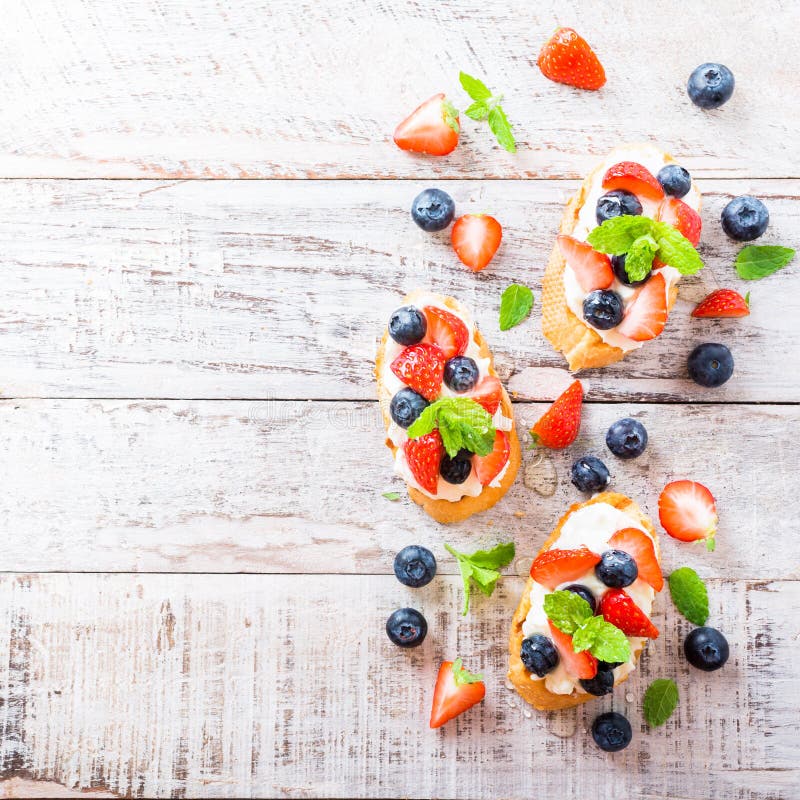 Crostini mit gegrilltem Stangenbrot-, Frischkäse und Beeren stockfotografie Crostini mit gegrilltem Stangenbrot-, Frischkäse und Beeren stockfotografie