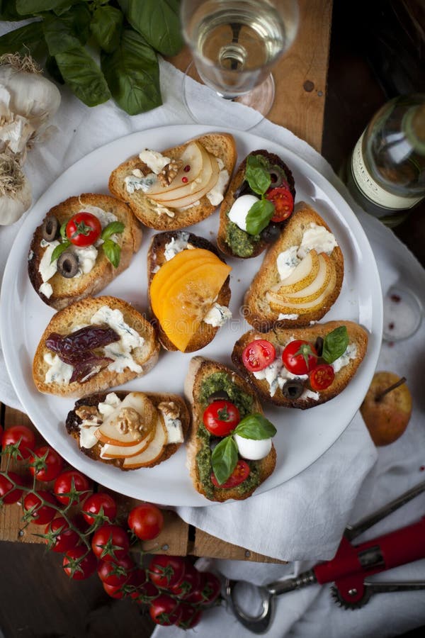 Crostini och bruschetta med ost, pears, persimmonen och honung royaltyfri fotografi Crostini och bruschetta med ost, pears, persimmonen och honung royaltyfri fotografi