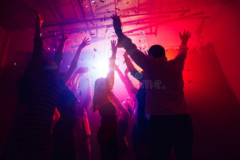 A Crowd of People in Silhouette Raises Their Hands Against Colorful ...