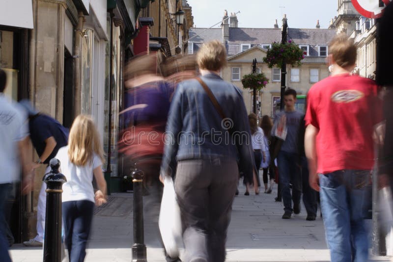 Folla di acquirenti su una lunga strada alta scattate con tempi di posa lenti di sfocatura persone.
