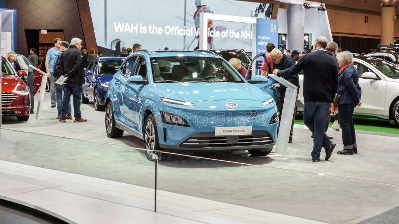 Crowds looking at new car models at Auto show. Hyundai Kona electric car on display. National Canadian Auto Show with many car royalty free stock image