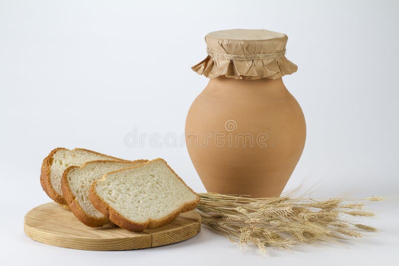 Cruche de lait avec les oreilles fraîchement cuites au four de pain blanc et de blé photo libre de droits Cruche de lait avec les oreilles fraîchement cuites au four de pain blanc et de blé photo libre de droits