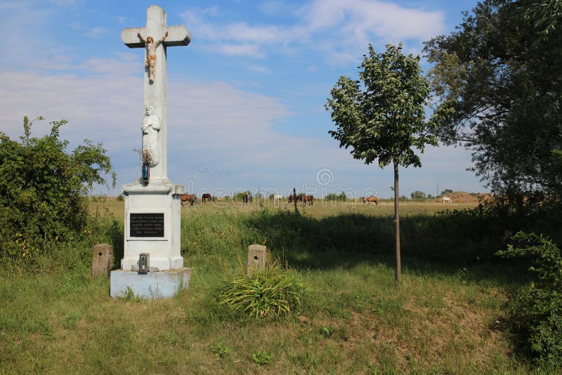 Crucifix in hayfield with horses near Devinska Nova Ves