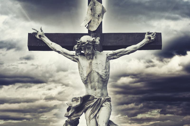 Crucifixion. Christian cross with Jesus Christ statue over stormy clouds. religion and spirituality concept.