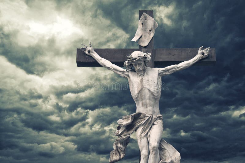 Crucifixion. Christian cross with Jesus Christ statue over stormy clouds. religion and spirituality concept.