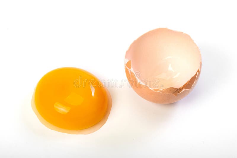 Crude egg yolk and shell on a white background. Close up. Top view