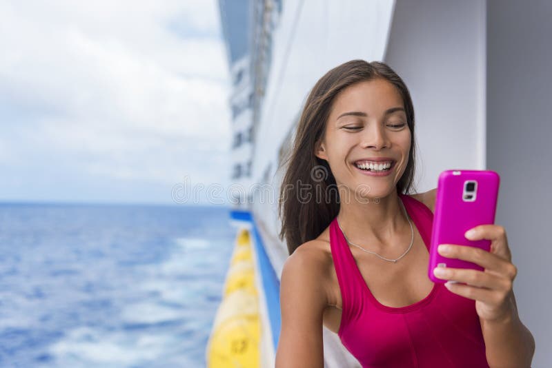 Cruise ship woman using mobile phone on travel vacation at sea. Asian girl texting sms on boat wifi cellular data cellphone