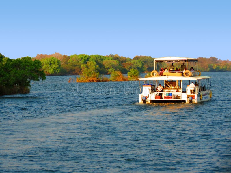 Cruise boat or catamaran on the Zambezi River, sunset appreciation with hippos. Cruise boat or catamaran on the Zambezi River, sunset appreciation with hippos.