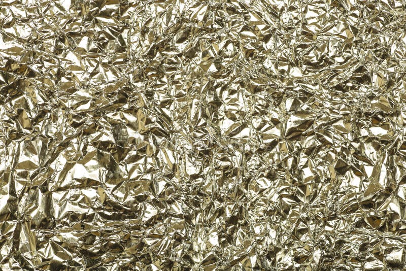 Crumpled foil background. The texture of crumpled iron aluminum gold reflective color. Copy space