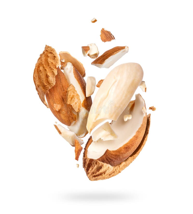 Crushed dried almonds with shell in air close up, isolated on white background royalty free stock photography
