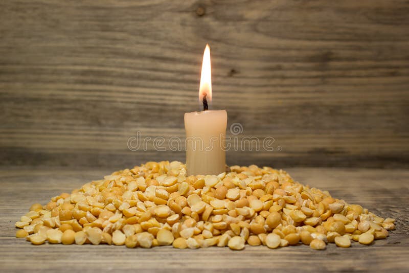 Crushed dried peas and burning candle royalty free stock photo