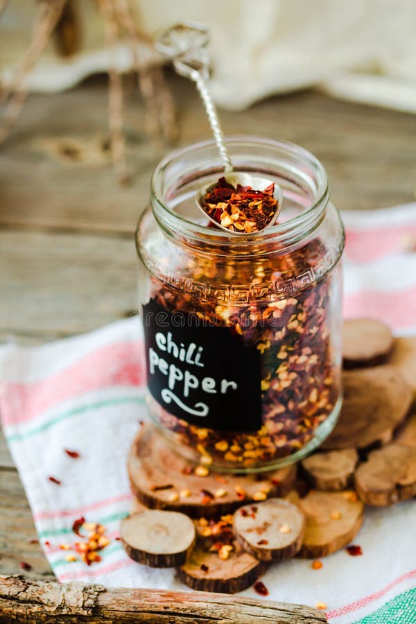 Crushed Red Pepper Flakes in a Shaker on a Wooden Table. Stock Photo