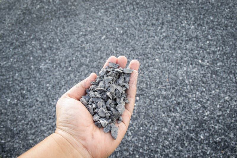 Crushed stone in hand. Crushed stone or angular rock is a form of construction aggregate