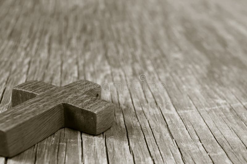 Cruz cristã de madeira em uma superfície de madeira rústica, tonificação do sepia