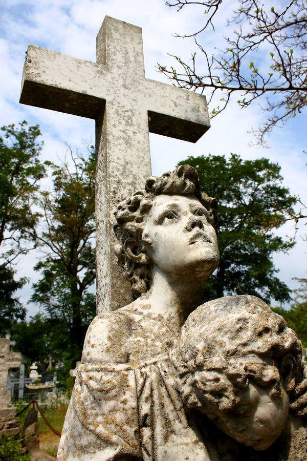 Cruz de piedra espeluznante con la estatua en el cementerio imagen de archivo libre de regalías Cruz de piedra espeluznante con la estatua en el cementerio imagen de archivo libre de regalías