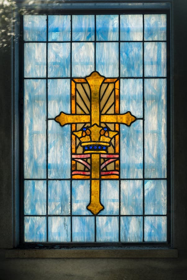 Cruze na janela de vitral na igreja que é ouro e cristandade azul fotos de stock Cruze na janela de vitral na igreja que é ouro e cristandade azul fotos de stock
