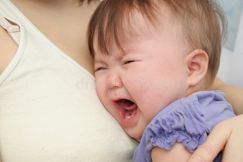 Crying baby at the mother on hands. Soothing upset child embracing and calming. Mother and daughter