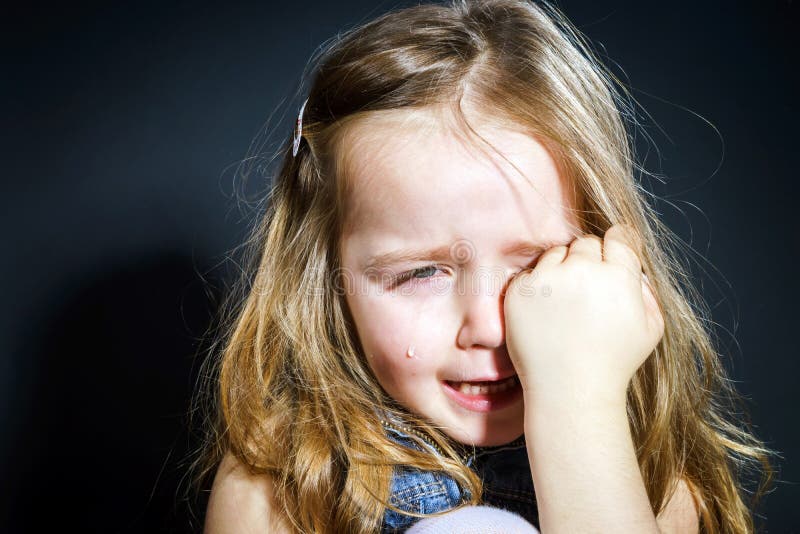 Crying blond little girl with focus on her tears