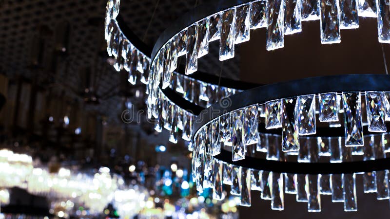Crystal chandelier with rectangular glass plates, abstract illumination, cold blue light backdrop background. Large crystal chandelier with transparent rectangular plates, glass refracts light. Large rectangular light source stock images, royalty-free photos and pictures