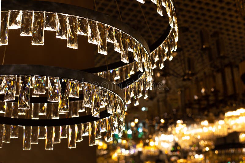 Crystal glass chandelier with thin transparent plates, abstract illumination, warm light backdrop background. Large chandelier with crystal rectangular plates, glass refracts light. Large rectangular light source stock images, royalty-free photos and pictures