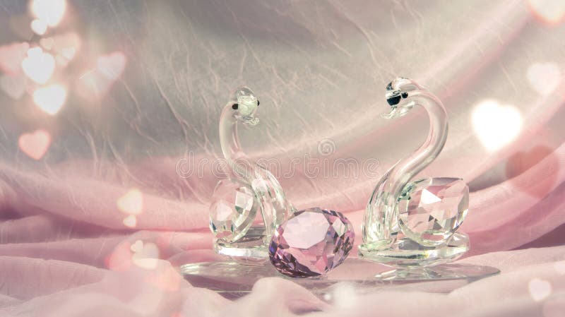 O bicchiere Cigni diamante sul rosa tessuto Circondato cuore.