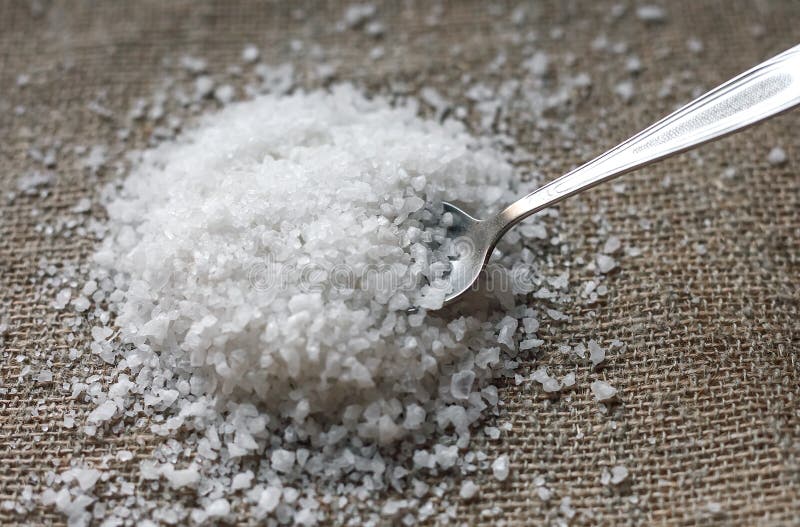 Crystals of Coarse Salt on the Table.the Spoon Takes the Salt. Stock