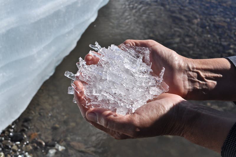 Crystals of ice from a glacier in human hands.