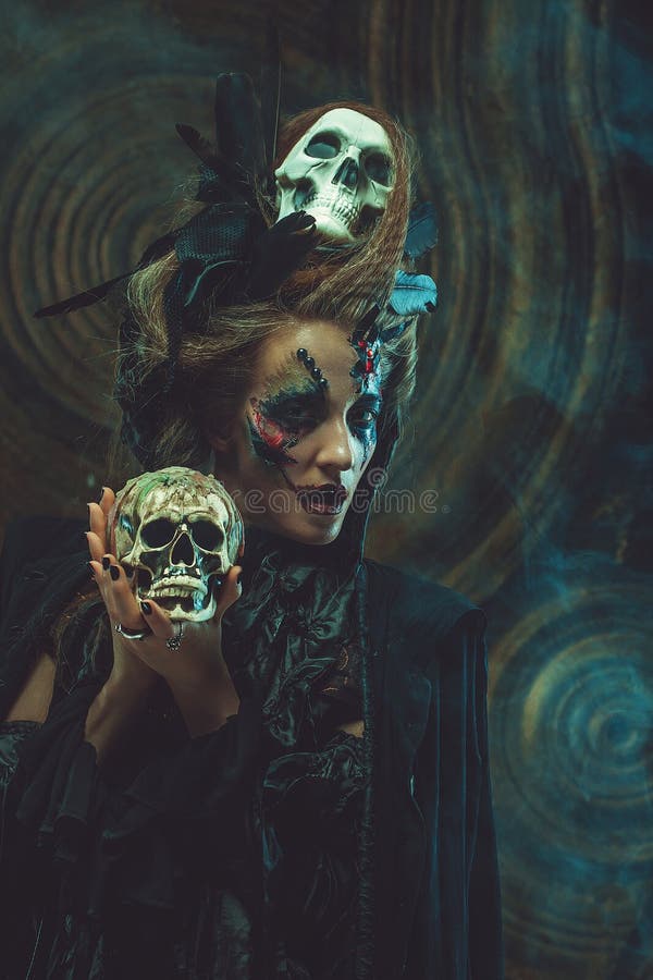 Cráneo hloding de la bruja joven Brillante componga y fume el tema de Halloween fotos de archivo libres de regalías Cráneo hloding de la bruja joven Brillante componga y fume el tema de Halloween fotos de archivo libres de regalías