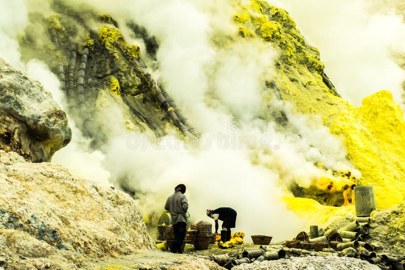 Cráter y mineros del volcán de Kawah que fuman Ijen en la mina de azufre, Indonesia imagen de archivo libre de regalías Cráter y mineros del volcán de Kawah que fuman Ijen en la mina de azufre, Indonesia imagen de archivo libre de regalías