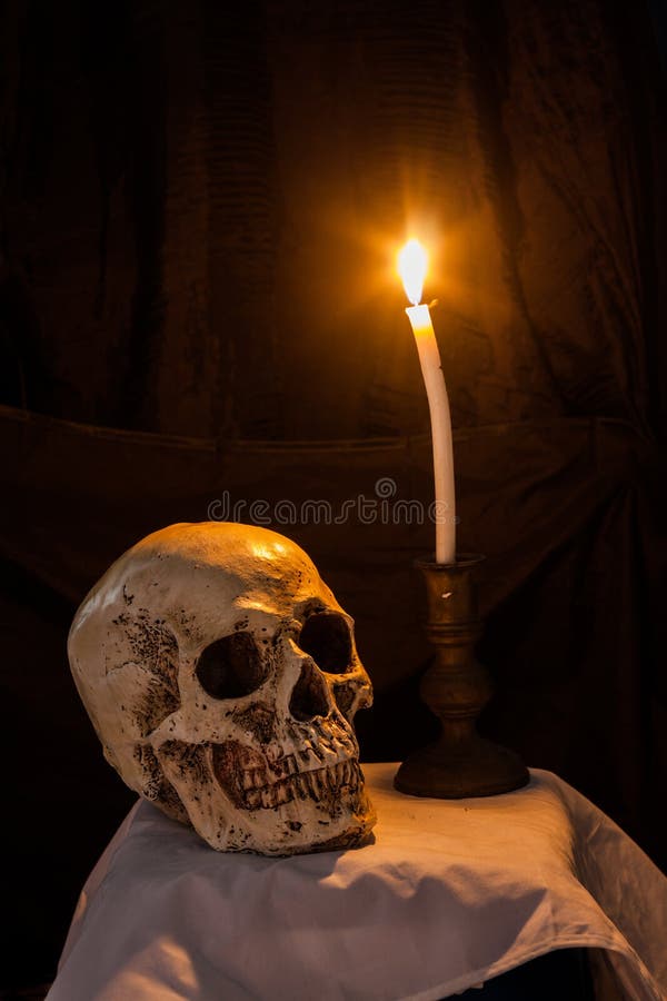 Crânio humano e vela ardente imagens de stock Crânio humano e vela ardente imagens de stock