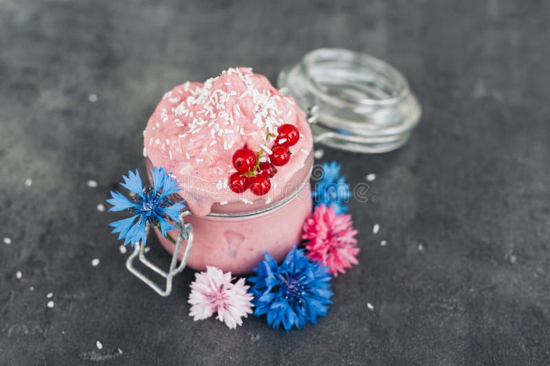 Cr?me glac?e d?licieuse de fraise d?cor?e des flocons de noix de coco, de la groseille rouge et des bleuets bleus sur le fond gri photos stock Cr?me glac?e d?licieuse de fraise d?cor?e des flocons de noix de coco, de la groseille rouge et des bleuets bleus sur le fond gri photos stock