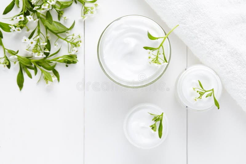 Crème hygiénique cosmétique de bodycare de fines herbes avec des fleurs photos stock Crème hygiénique cosmétique de bodycare de fines herbes avec des fleurs photos stock