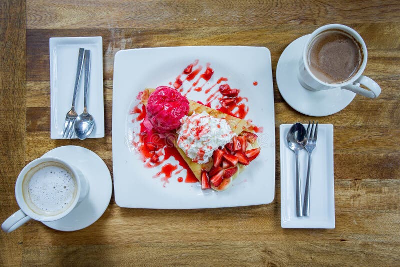 Crêpe de fraise de crème glacée de dessert et boisson chaude dans le café image libre de droits Crêpe de fraise de crème glacée de dessert et boisson chaude dans le café image libre de droits