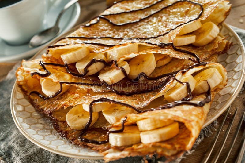 Crêpe fritti saporiti della pastella con le banane fresche immagine stock libera da diritti Crêpe fritti saporiti della pastella con le banane fresche immagine stock libera da diritti