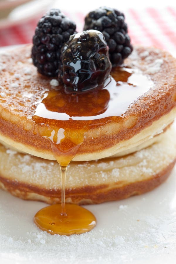 Delicious pancakes stacked together with blackberries and honey. Delicious pancakes stacked together with blackberries and honey