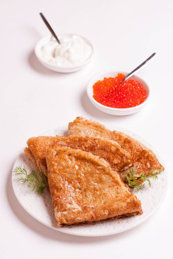 Crêpes délicieuses avec le caviar, l'aneth rouge et la crème sure, d'isolement image stock Crêpes délicieuses avec le caviar, l'aneth rouge et la crème sure, d'isolement image stock
